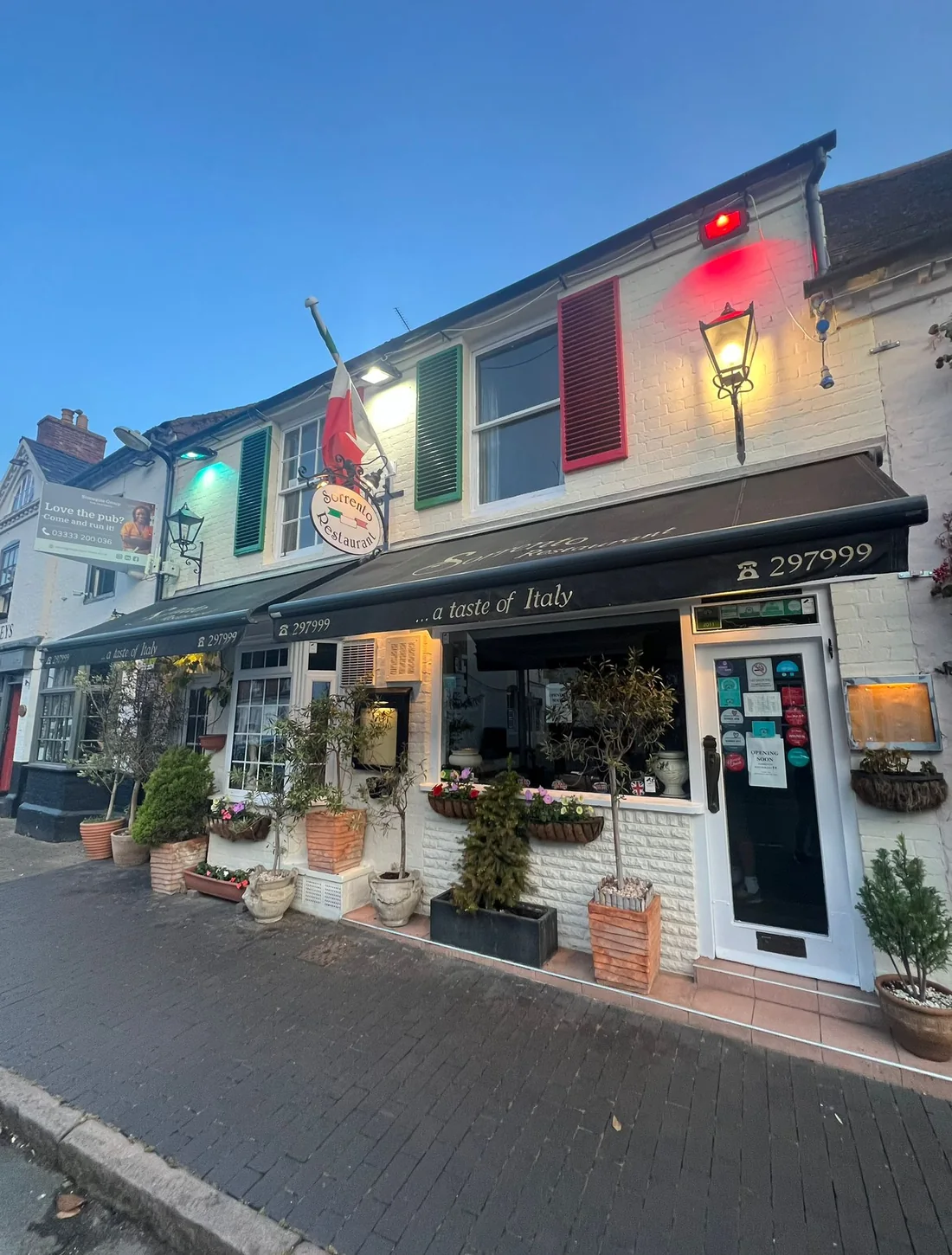 Sorrento Restaurant's white frontage with Italian red and green shutters on Ely Street
